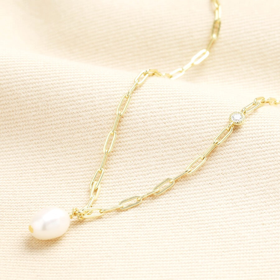 Gold chain necklace with a freshwater pearl displayed.