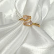 Gold ring with two pink quartz gemstones on a white satin background