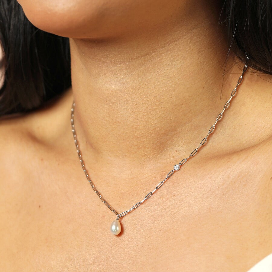 silver chain Necklace with a pearl pendant and crystal drop worn by a person